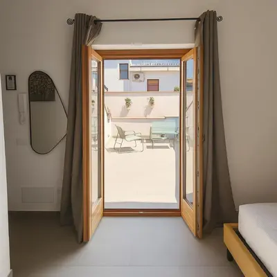 a bedroom with a door open to a patio at Borgo di Mare in Palermo