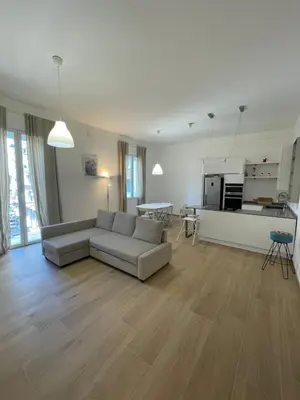a living room with a couch and a kitchen at Iazzu Apartament in Palermo