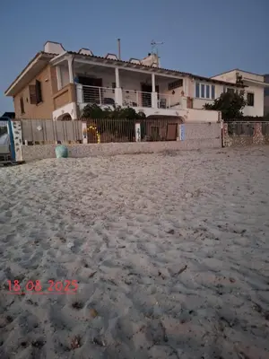 a house on a sandy beach with a fence at Le Terrazze sul mare Joelle -The uniqueness of the Terrace overlooking the sea in Carini