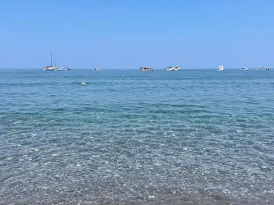 a large body of water with boats in the distance at Ombelico di VenereVilla in Mandra Capreria