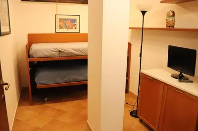 a bedroom with a bunk bed and a desk with a computer at Homedaf in Carini