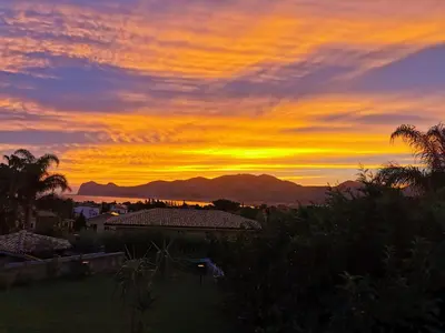 a sunset over a city with mountains in the background at Homedaf in Carini