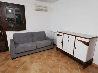 a couch sitting in a living room with a counter at Homedaf in Carini