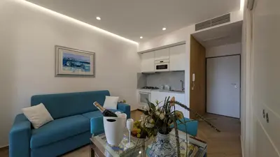 a living room with a blue couch and a table at Mondello D'Amare in Palermo