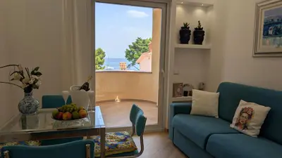 a living room with a couch and a table and a window at Mondello D'Amare in Palermo