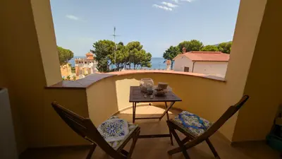 a small table and chairs on a balcony with a view at Mondello D'Amare in Palermo