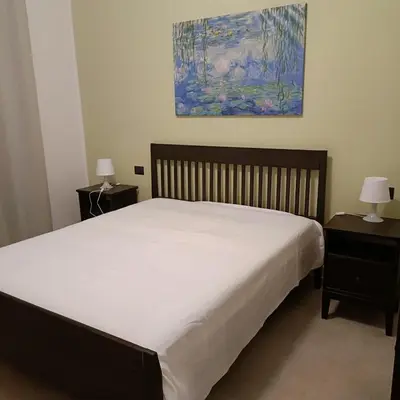 a bedroom with a white bed with two night stands at Ma Home in Cinisi