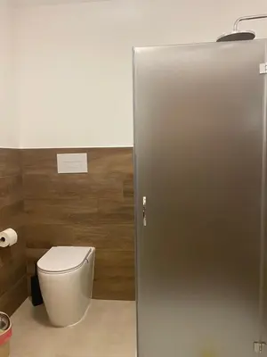 a bathroom with a toilet and a toilet paper dispenser at Ma Home in Cinisi