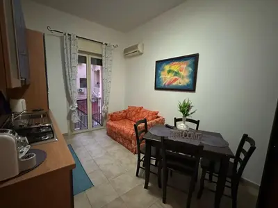 a kitchen and living room with a table and a couch at A 2 passi dal Politeama in Palermo