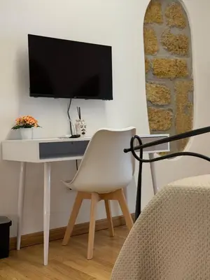 a white desk with a television on a wall at VUCCIRIA' S ROOM centro storico in Palermo