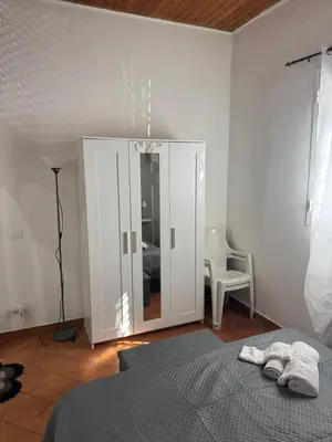 a bedroom with a bed and a cabinet with a mirror at Casa la Fenice in Palermo