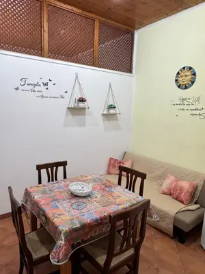 a dining room with a table and a couch at Casa la Fenice in Palermo