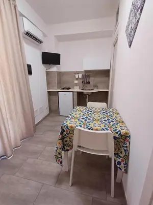 a table and chairs in a room with a kitchen at Studio 23 in Partinico