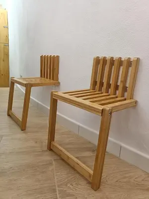 two wooden chairs sitting next to a wall at Il Pirtuso in Palermo