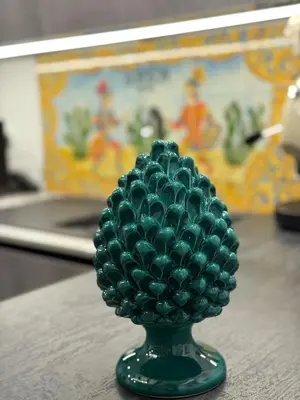 a green vase filled with green balls sitting on a table at Borbon Home luxury rooms & SPA in Palermo