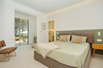 a bedroom with a large bed and a desk at Villa Marinjo in Alcamo