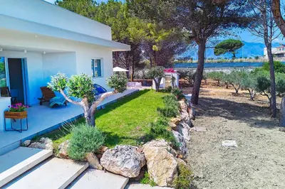 a house with a yard with a rock wall at Villa Marinjo in Alcamo