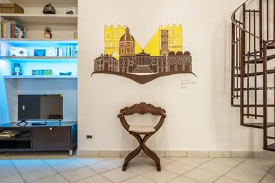 a chair in a room with a wall with a picture of the city at A casa di GIO&GRACE in Palermo