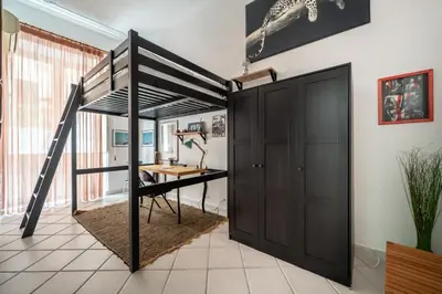 a loft bed with a desk in a room at A casa di GIO&GRACE in Palermo
