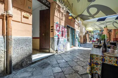 an alley with a table and an umbrella on a street at A casa di GIO&GRACE in Palermo