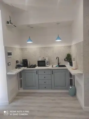 a kitchen with white counters and a counter top at Summer House in Isola delle Femmine