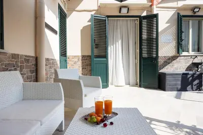 a table with two glasses of orange juice on a patio at Uditore Mini Apartment in Palermo