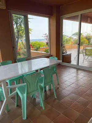 a large table and chairs with a view of the ocean at Villa Fiory in Terrasini