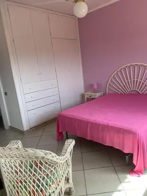 a bedroom with a pink bed and a white cabinet at Villa Fiory in Terrasini