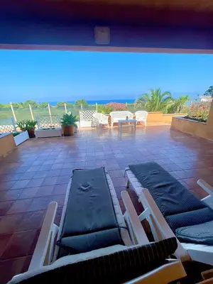 a patio with lounge chairs and a view of the ocean at Villa Fiory in Terrasini