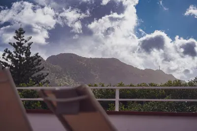 a chair sitting on a balcony with a mountain at Casa TreMar - Flat with roof top in Mondello in Palermo