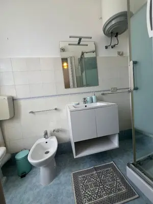 a bathroom with a sink and a toilet and a mirror at Casa TreMar - Flat with roof top in Mondello in Palermo