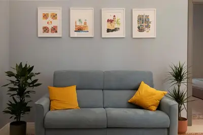 a blue couch with yellow pillows in a living room at Suite80 in Palermo