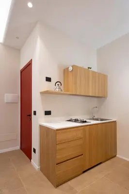 a kitchen with a counter and a sink and a red door at Suite80 in Palermo