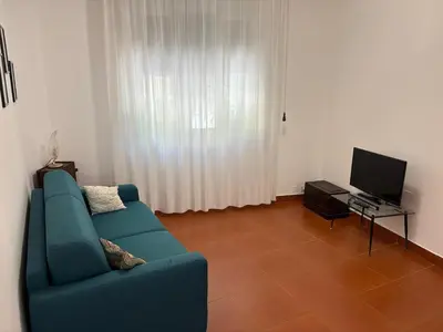 a living room with a blue couch and a television at Villa Cetti a Mondello in Palermo