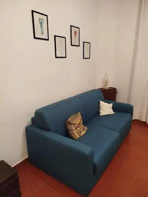 a blue couch in a living room with pictures on the wall at Villa Cetti a Mondello in Palermo
