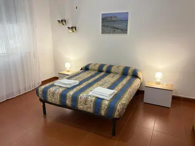 a bedroom with a bed with two night stands and two lamps at Villa Cetti a Mondello in Palermo