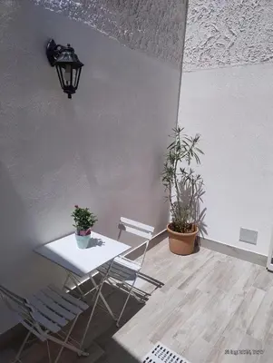 a room with a table and chairs and plants at Le casette di Elia e Alice in Palermo