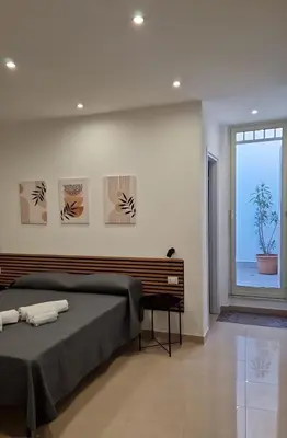 a bedroom with a large bed and a window at Le casette di Elia e Alice in Palermo