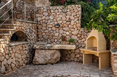 a stone wall with a sink and a stone oven at Villa Luna Scopello in Castellammare del Golfo