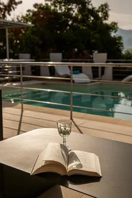 a book and a glass of wine sitting on a table at Villa Luna Scopello in Castellammare del Golfo