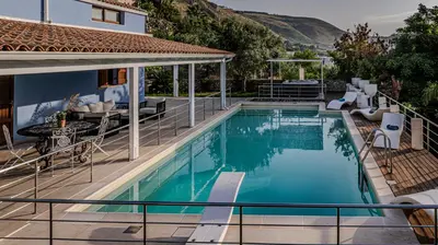 a swimming pool with a patio and a house at Villa Luna Scopello in Castellammare del Golfo