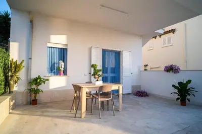 a table and chairs in a room with plants at Casa vacanze CaMi in Alcamo