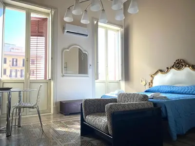 a bedroom with a bed and a chair and a table at House Wonderfull Palermo in Palermo