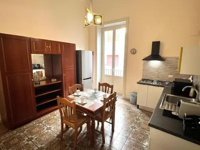 a kitchen with a table and chairs and a refrigerator at House Wonderfull Palermo in Palermo