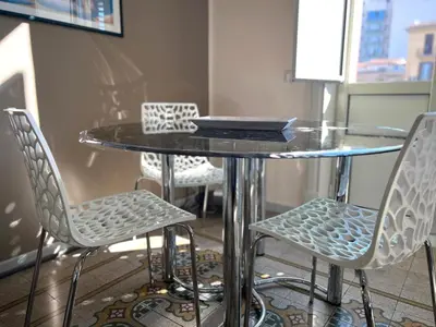 a glass table with four chairs around it at House Wonderfull Palermo in Palermo