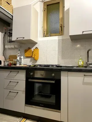 a kitchen with white cabinets and a black oven at La Casetta di Fortunata in Palermo
