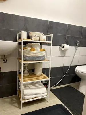 a bathroom with a shelf with towels and a toilet at La Casetta di Fortunata in Palermo