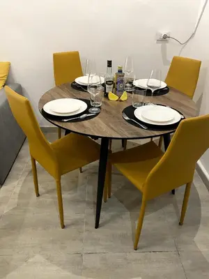 a wooden table with chairs and plates and wine glasses at La Casetta di Fortunata in Palermo