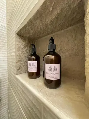 two bottles of soap sitting on a shelf at Bìfara Rooms in Palermo