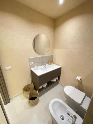 a bathroom with a sink and a toilet and a mirror at Bìfara Rooms in Palermo